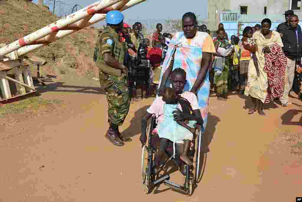 A United Nations soldier stands guard as civilians arrive at the UNMISS compound adjacent to Juba International Airport to take refuge, Dec. 17, 2013. (UNMISS)