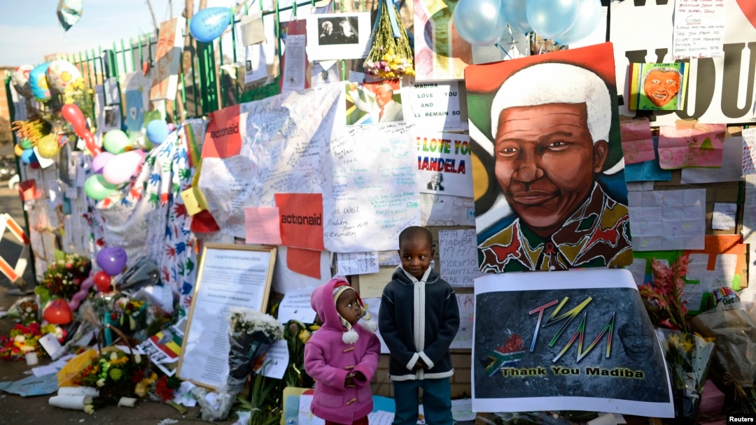 Anak-anak Afrika Selatan berpose di depan rumah sakit jantung Medi-Clinic, tempat mantan Presiden Afrika Selatan Nelson Mandela dirawat di Prestoria, Afrika Selatan (27/6). Kondisi Mandela dikabarkan lembali stabil setelah mengalami masa kritis.
