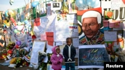 Anak-anak Afrika Selatan berpose di depan rumah sakit jantung Medi-Clinic, tempat mantan Presiden Afrika Selatan Nelson Mandela dirawat di Prestoria, Afrika Selatan (27/6). Kondisi Mandela dikabarkan lembali stabil setelah mengalami masa kritis.