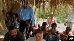 FILE photo showing Microsoft co-founder Bill Gates, center, in a remote village in eastern India to see the progress of the Indian government's campaign to eradicate polio.