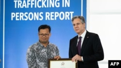 FILE - U.S. Secretary of State Antony Blinken stands with Mech Dara, a 2023 Trafficking in Persons Report Hero, for work in Cambodia at the State Department in Washington, June 15, 2023. 