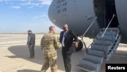 U.S. Defense Secretary Lloyd Austin is greeted next to a plane by Major General Matthew McFarlane, during his unannounced trip to Baghdad, Iraq, March 7, 2023. 