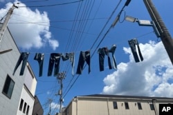 Pairs of jeans flap over Jeans Street in Kojima, Okayama prefecture, Japan, on Sept. 4, 2024. (AP Photo/Yuri Kageyama)