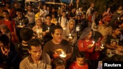 Sitwayen endonezyen ki reyini pou yon veye-o-chandèl nan memwa viktim aksidan avyon AirAzi, Vòl 8501 an. (Foto: Vil Surabaya, 31 desanm 2014). 
