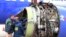 National Transportation Safety Board investigators examine damage to the engine of the Southwest Airlines plane that made an emergency landing at Philadelphia International Airport, April 17, 2018. The engine blew at 32,000 feet. 