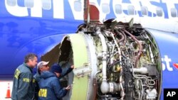 Para penyelidik NTSB memeriksa pesawat Southwest Airlines yang rusak dan terpaksa melakukan pendaratan darurat di bandara Philadelphia, Selasa (17/4). 