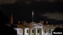 FILE - The White House is lit before dawn after U.S. President Donald Trump announced that he and U.S. first lady Melania Trump have both tested positive for the coronavirus disease, in Washington, Oct. 2, 2020.