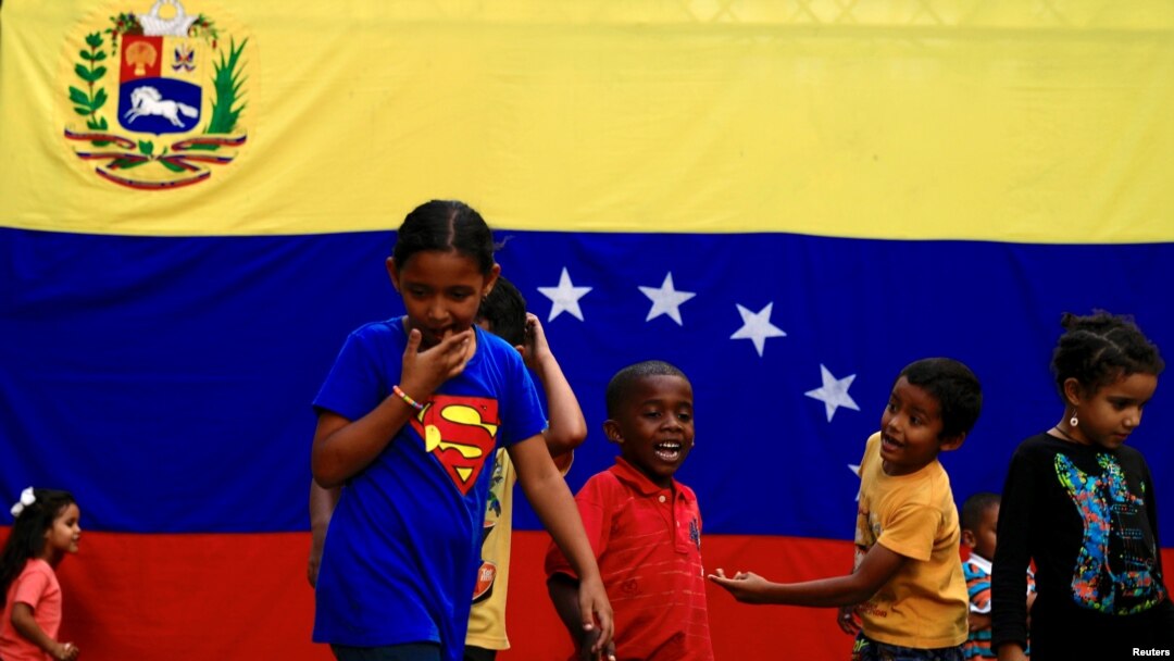 Un grupo de niños juega en las calles, frente a una bandera de Venezuela. Imagen de archivo del 7 de septiembre de 2019.