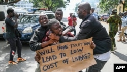 FILE - Kenyan plain clothed police officers detain an activist during a protest over tax hike plans in Nairobi on June 6, 2023.