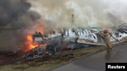 A firefighter tries to extinguish a fire at the site of a crash, in the Victoria-Zaragoza highway, Tamaulipas, Mexico, May 14, 2023, in this photo released and distributed by Secretaria de Seguridad Publica Tamaulipas/Handout via REUTERS