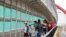 FILE - Residents with visas cross the Puerta Mexico bridge to enter the U.S., in Matamoros, Mexico, June 28, 2019. U.S. President Joe Biden on May 14, 2021, revoked a Trump-era proclamation that sought to bar entry of immigrants without health coverage.