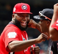 FILE - World Team Manager David Ortiz (34) speaks with U.S. Team Manager Torrii Hunter, before the All-Star Futures baseball game at Nationals Park, in Washington, July 15, 2018.