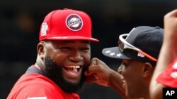FILE - World Team Manager David Ortiz (34) speaks with U.S. Team Manager Torrii Hunter, before the All-Star Futures baseball game at Nationals Park, in Washington, July 15, 2018.