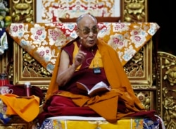 FILE - The Dalai Lama delivers a message as he attends a fair in Milan, Italy.
