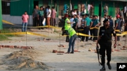 Members of Crime Scene Unit investigate the spot where an unidentified intruder died in a blast after attempting to enter the camp of Rapid Action Battalion (RAB) in Dhaka, Bangladesh, March 17, 2017. Another suspected militant armed with explosives died Saturday trying to ride a motorcycle through a security checkpoint.