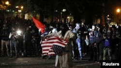 资料照片：在俄勒冈州的波特兰市，一名示威者举着美国国旗抗议警察暴力和种族不平等。(2020年9月26日)