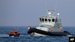 A Border Force vessel assists a group of people thought to be migrants on board from their inflatable dinghy in the English Channel. The British government tries to curb the number of people crossing from France in small boats.