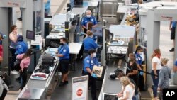 Transportation Security Administration agents process passengers at the south security checkpoint in Denver International Airport on June 10, 2020, in Denver, as travelers deal with the effects of the new coronavirus. 