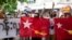 Protesters holding National League for Democracy (NLD) flags raise three-finger salutes during flash protests against the military coup at Bahan township in Yangon, Myanmar, June 25, 2021. 