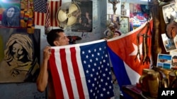 Un hombre muestra banderas cubanas y estadounidenses en su casa de La Habana, el 29 de julio de 2020. - Hace cinco años, la embajada de Estados Unidos reabrió en La Habana como parte de un enfoque histórico.