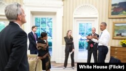 FILE - President Barack Obama talks with national security staff in the Oval Office after being notified of the nuclear agreement with Iran.