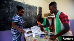 Une femme s'enregistre pour voter dans un bureau de vote à Abidjan, Côte d'Ivoire, le 18 décembre 2016.