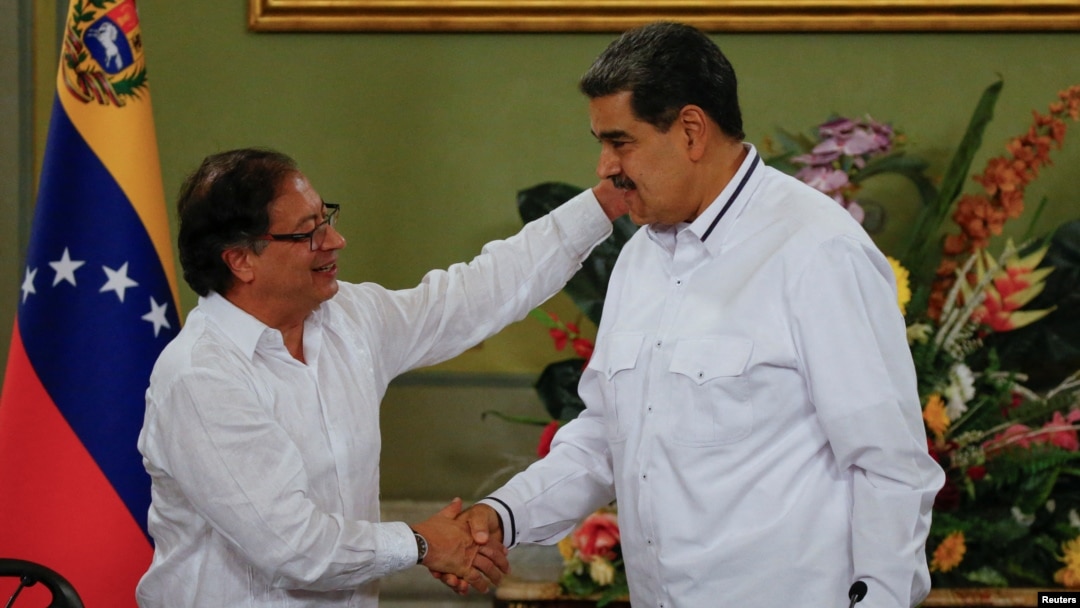 Los presidentes de Colombia y Venezuela, Gustavo Petro y Nicolás Maduro, estrechan sus manos sonrientes en una reunión en el Palacio de Miraflores, en Caracas, el 18 de noviembre de 2023.
