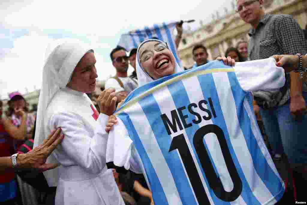 A nun holding an Argentine national soccer team jersey with the number of player Lionel Messi, smiles as she waits for Pope Francis&#39; Sunday Angelus prayer in Saint Peter&#39;s square at the Vatican.