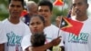 Warga Timor Leste memegang bendera kebangsaannya, di Dili, Timor Leste, Jumat, 30 Agustus 2019, menandai peringatan 20 tahun referendum yang yang mengakhiri 24 tahun pendudukan Indonesia dan memberikan kemerdekaan bagi negara bekas koloni Portugal tersebut. (Foto: dok).