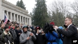 ສະ​ມາ​ຊິກ​ສະ​ພາ ທ່ານ ແມັ​ຕ ເຊ (Matt Shea) ກ່າວ​ຖະ​ແຫລງ​ຢູ່​ທີ່ ການ​ໂຮມ​ຊຸມ​ນຸມ ກຸ່ມ​ປົກ​ປ້ອງ​ສິດ​ໃນ​ການ​ຄອບ​ຄອງ​ປືນ, ​ບ່ອນ​ທີ່​ພວກ​ໄປ​ຊຸມ​ນຸມຫຼາຍ​ຄົນ ໃຫ້​ການ​ສະ​ໜັບ​ສະ​ໜຸນ ສະ​ມາ​ຊິກ​ສະ​ພາ​ດັ່ງ​ກ່າວ, ວັນ​ທີ 17 ມັງ​ກອນ 2020, ​ໃນ​ເມືອງ​ໂອ​ລິມ​ເປຍ ລັດ​ວ​ໍ​ຊິງ​ຕັນ.