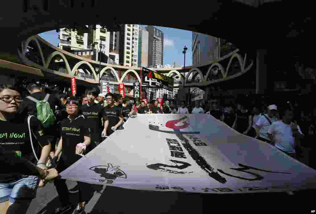 Protesters carry a huge banner with Chinese words &quot;Exonerate the June 4 Protest&quot; as thousands of people march on a downtown street in Hong Kong to mark the 25th anniversary of China&#39;s bloody crackdown on Tiananmen Square on June 4, 1989.