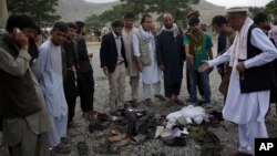 Men try to recognize the victims from the remains of their clothes at the site of three suicide attacks, in Kabul, Afghanistan, Jun 3, 2017.