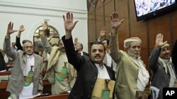 Members of Yemen's parliament raise their hands as they vote in favor of the state of emergency, March 23, 2011, declared by the country's President Ali Abdullah Saleh last week, in Sana'a