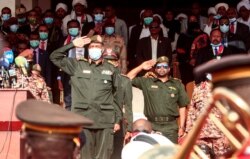 FILE - Chairman of Sudan's Sovereignty Council General Abdel Fattah al-Burhan performs a military salute during a reception ceremony upon the arrival of the government negotiating team from Juba, in the capital Khartoum, Oct. 8, 2020.