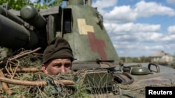 FILE PHOTO: An Ukrainian soldier looks out from a tank, amid Russia's invasion of Ukraine, in the frontline city of Lyman, Donetsk region