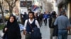 FILE - Amir Ali Najafi, center, a transgender man, walks on a sidewalk in Tehran, Iran, March 11, 2018. Transgender men and women can face harassment in Iran, despite a religious order acknowledging them. 