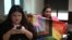 LGBTQ+ activist Waaddao Chumaporn holds a pride flag while in a waiting room with activist and representative of the marriage-equality bill Chanya Rattanatada at Thai Parliament in Bangkok on April 2, 2024, ahead of the first reading of the bill to the Senate.