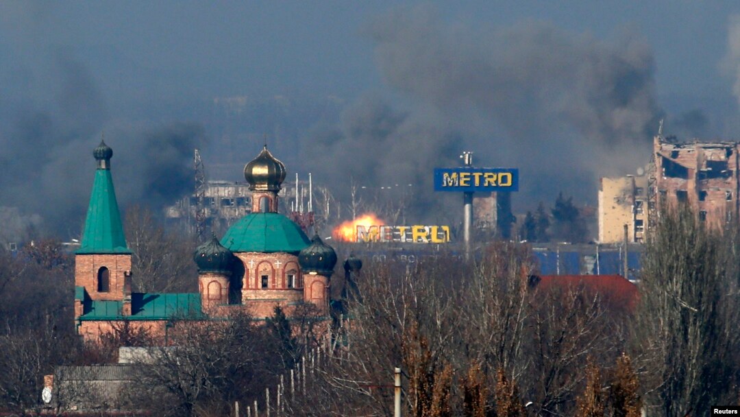 Asap tampak di terminal tua, kiri, dan sebuah gedung di bandara setelah tembakan artileri dalam pertempuran antara separatis pro-Rusia dan pemerintah Ukraina di Donetsk, Ukraina timur, Minggu (9/11).