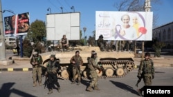 Fighters of Hayat Tahrir al-Sham (HTS) walk together during what they said was security checks to find "remnants" of ousted Syrian President Bashar al-Assad's force, in Wadi al-Dahab neighborhood in Homs, Syria, Jan. 2, 2025.