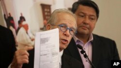 Attorney Jeff Anderson, left, with Manuel Vega, who says he was sexually abused by a priest over a five-year period decades ago, describes Vega's lawsuit against the Vatican, seeking the names of all offenders within the church worldwide, at a news conference in Los Angeles, Oct. 4, 2018. 