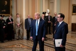 President Donald Trump, joined by Treasury Secretary Steven Mnuchin, right, speaks to reporters after meeting with Republican senators, on Capitol Hill in Washington, Tuesday, March 10, 2020.
