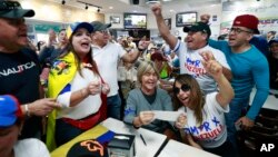 Venezolanos gritaban Viva Venezuela mientras miraban en televisión las noticias de su país en el restaurante venezolano El Arepazo en Doral, Florida, el martes, 30 de abril de 2019.