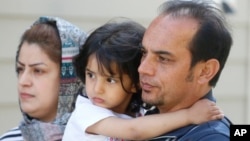 In this April 22, 2020, photo, Afghan refugee Mahmood Amiri poses with daughter Safa, and his wife Masouda, in West Valley City, Utah. Coronavirus restrictions have affected refugee families and many are navigating the turmoil in a language they don't fully understand. (AP Photo)