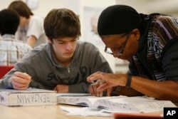 ILUSTASI - James Montalbano, siswa kelas 11, didampingi gurunya, Angela Benjamin di kelas Fisika Advanced Placement (AP) di Woodrow Wilson High School di Washington, Jumat, 7 Februari 2014. (Charles Dharapak/AP)