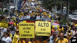 Hondureños enarbolan carteles por la paz y contra la corrupción, en una protesta en Tegucigalpa, la capital, en 2012.