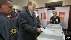 A man casts his ballot paper at a polling station in the town of Khimki outside Moscow, Russia, October 14, 2012. 