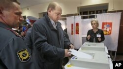 Pemilih memasukkan kartu suara di Khimki, di luar ibukota Moskow, Rusia (14/10). Partai Rusia Bersatu yang berkuasa memenangkan pemilu lokal Rusia.