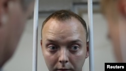 Ivan Safronov, a former journalist who works as an aide to the head of Russia's space agency Roscosmos, detained on suspicion of treason stands inside a defendants' cage before a court hearing in Moscow, Russia, July 7, 2020.