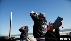 Warga AS memotret balon mata-mata yang diduga milik China saat mengapung di lepas pantai Surfside, South Carolina (4/2).