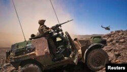 A French soldier stands guard in an armoured vehicle in the Terz valley, about 60 km (37 miles) south of the town of Tessalit in northern Mali March 21, 2013. 